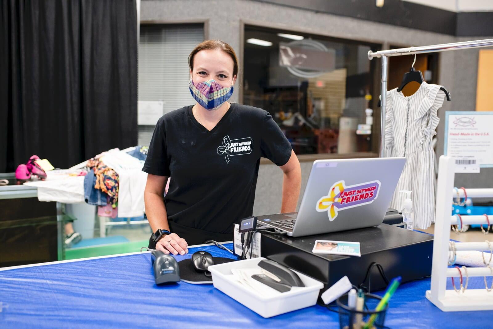 A cashier smiles behind her mask as she gets ready to check out the next happy JBF customer.
